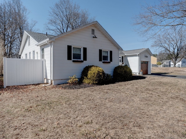 view of front of house featuring a garage, a front yard, and fence