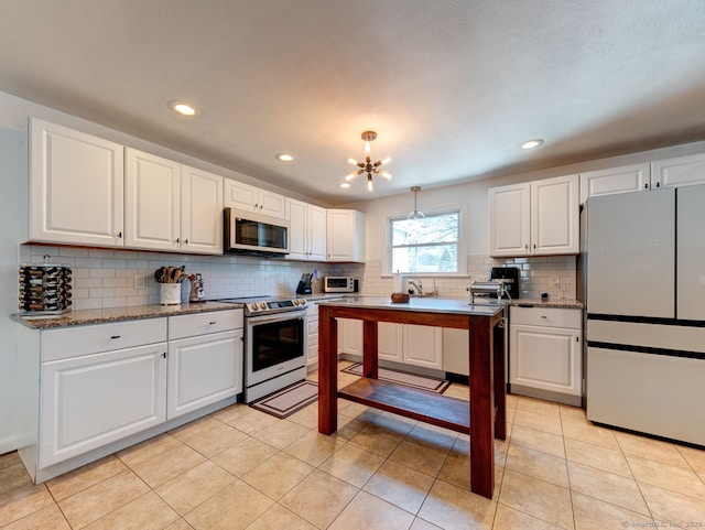 kitchen with a chandelier, decorative backsplash, white appliances, and white cabinetry