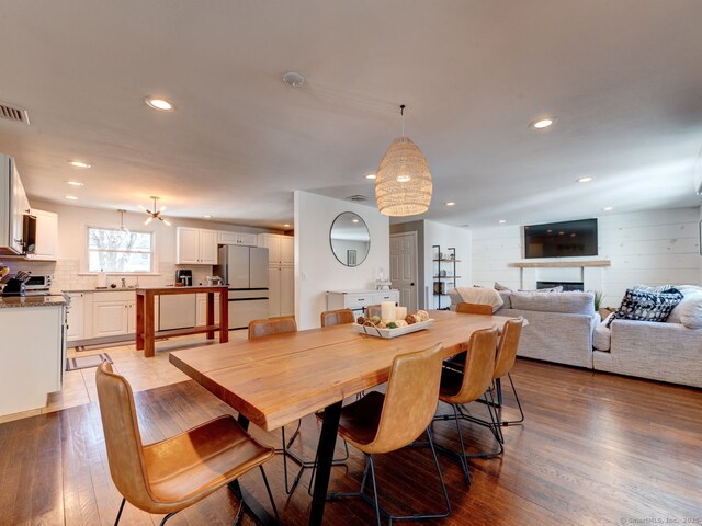 dining room with recessed lighting, visible vents, light wood-style flooring, and a fireplace