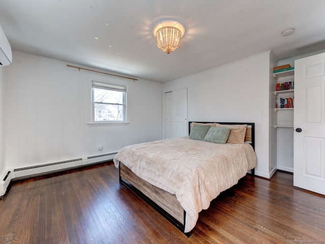 bedroom featuring hardwood / wood-style floors, a wall unit AC, a chandelier, and a baseboard radiator