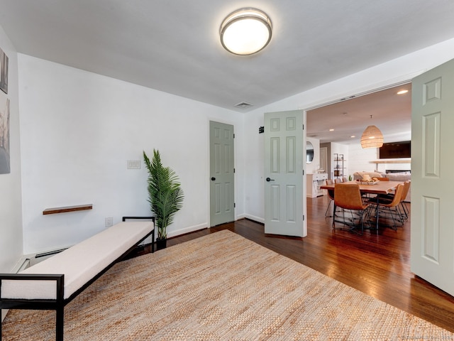 interior space with visible vents, recessed lighting, a baseboard radiator, baseboards, and dark wood-style flooring