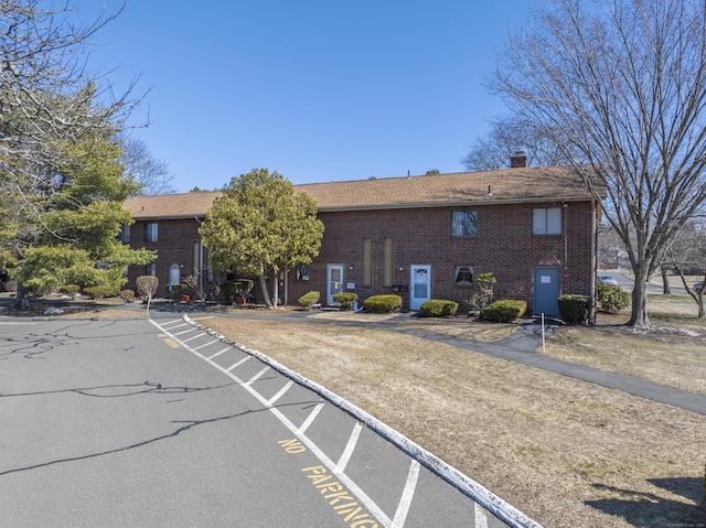 exterior space featuring brick siding and a chimney