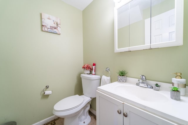 bathroom with baseboards, toilet, and vanity