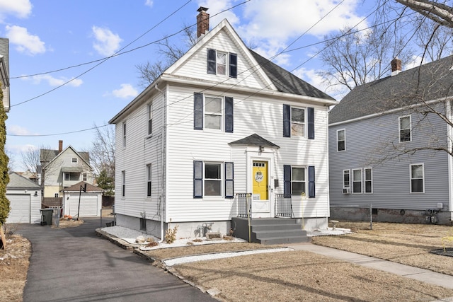 traditional style home featuring an outbuilding, a chimney, and a garage