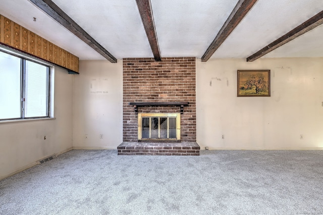 unfurnished living room featuring baseboards, beam ceiling, carpet, and a brick fireplace