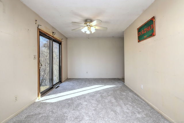 carpeted spare room with baseboards and ceiling fan