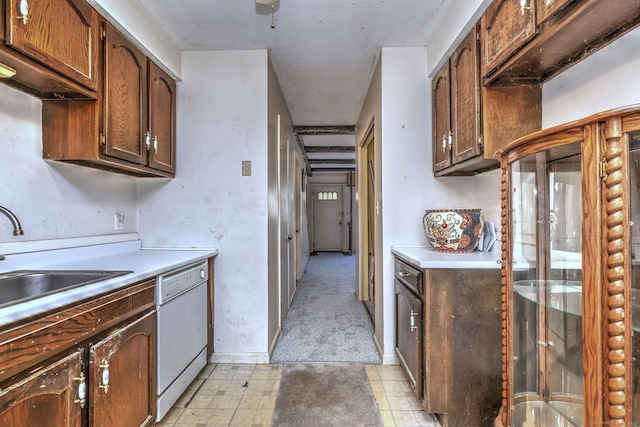 kitchen with light floors, dishwasher, light countertops, and a sink