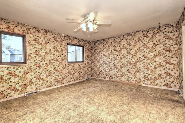 spare room featuring visible vents, carpet floors, and wallpapered walls