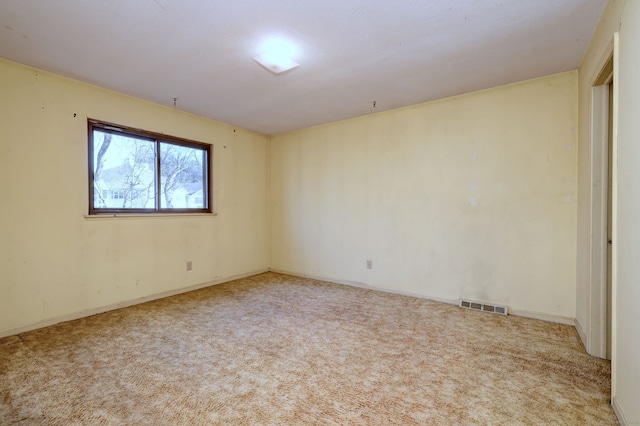 carpeted spare room featuring visible vents