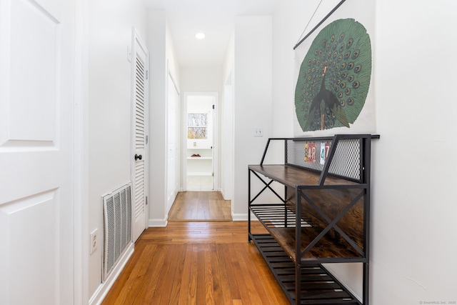 hall with visible vents, recessed lighting, baseboards, and wood-type flooring