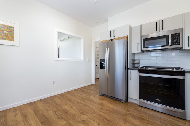 kitchen featuring decorative backsplash, light wood-style flooring, appliances with stainless steel finishes, and gray cabinetry