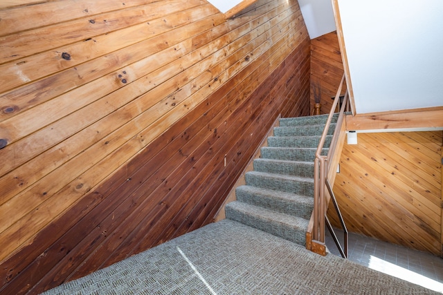 stairs featuring wood walls