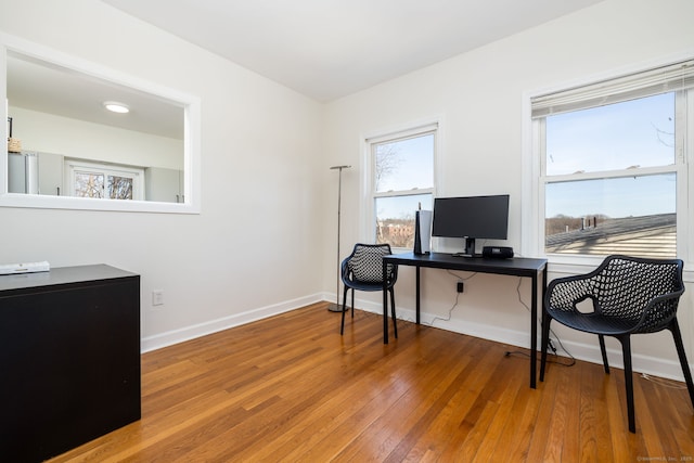 office space with baseboards and wood-type flooring