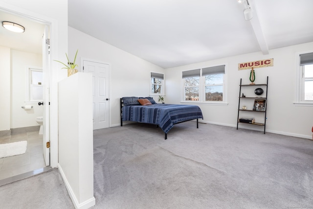 bedroom featuring baseboards, lofted ceiling with beams, and carpet