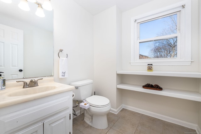 bathroom with baseboards, toilet, vanity, and tile patterned flooring