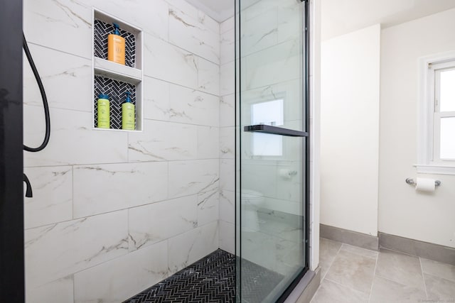 full bathroom with baseboards and a shower stall