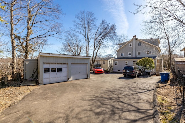 exterior space featuring a chimney, a detached garage, and an outdoor structure