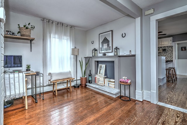 sitting room featuring baseboards, a ceiling fan, and hardwood / wood-style flooring