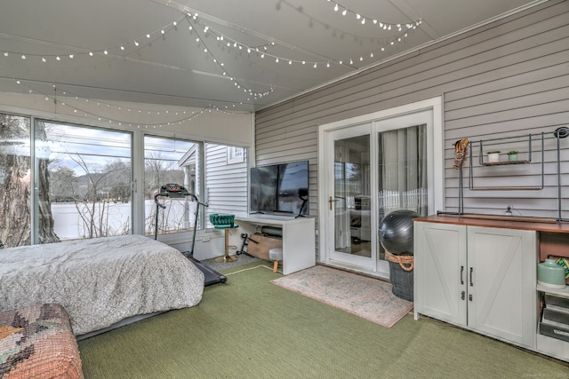 carpeted bedroom featuring wooden walls and access to exterior