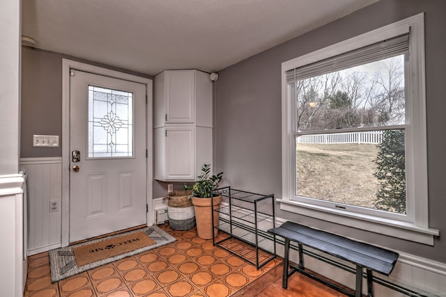 entrance foyer with a baseboard heating unit and wainscoting