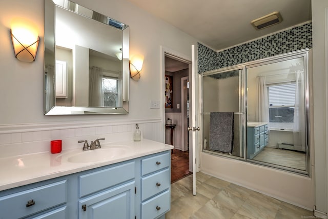 bathroom with a wainscoted wall, vanity, visible vents, and a baseboard radiator