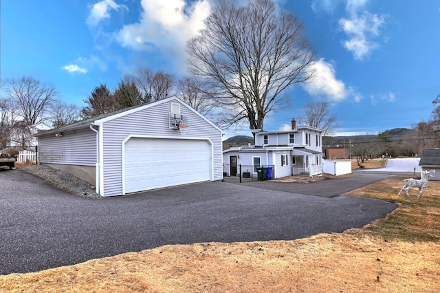 exterior space with an outbuilding, driveway, and fence