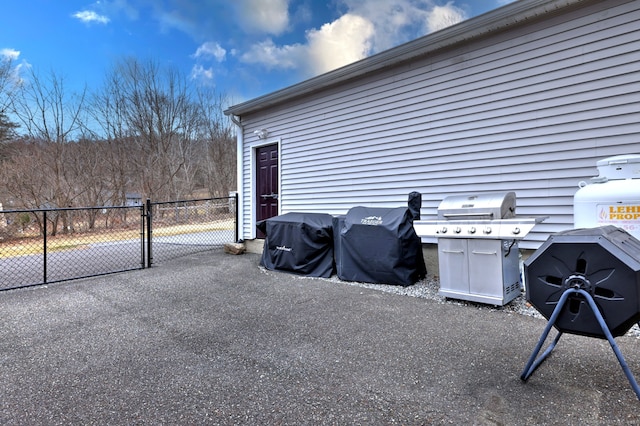 view of patio with a gate, fence, and a grill