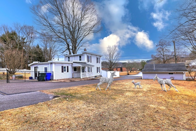 exterior space with aphalt driveway, fence, and a chimney