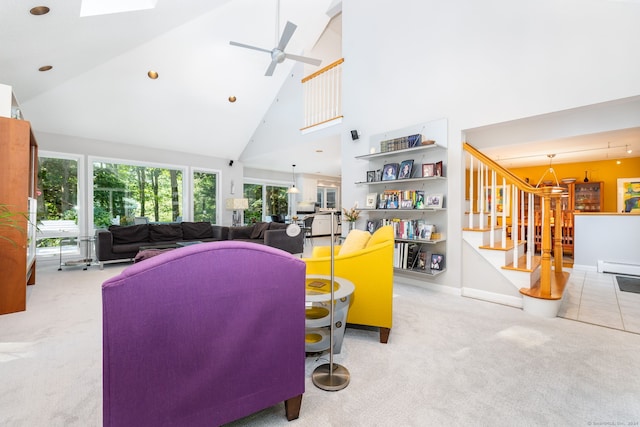 living room with carpet floors, high vaulted ceiling, a skylight, ceiling fan, and stairs