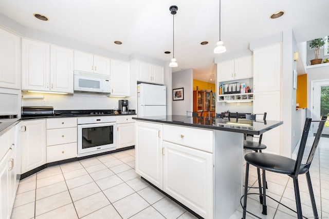 47 Jeremy River Dr, Colchester, CT 06415 - kitchen featuring white appliances, a breakfast bar, white cabinets, light tile patterned floors, and recessed lighting