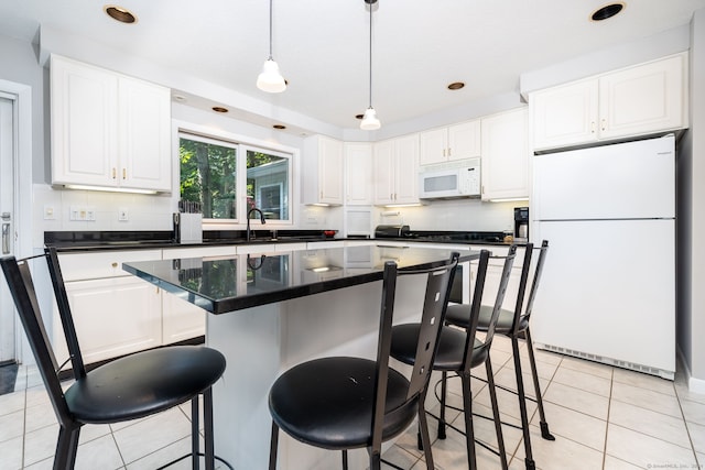 kitchen featuring white appliances, light tile patterned floors, white cabinetry, dark countertops, and tasteful backsplash