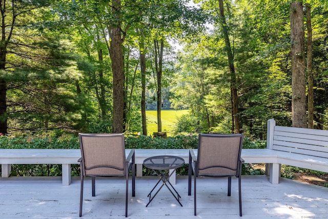 view of patio / terrace featuring a view of trees and a deck