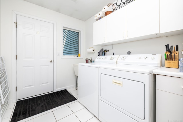 clothes washing area with light tile patterned floors, cabinet space, and separate washer and dryer