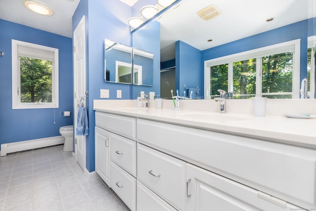 47 Jeremy River Dr, Colchester, CT 06415 - bathroom with baseboard heating, baseboards, toilet, tile patterned flooring, and double vanity
