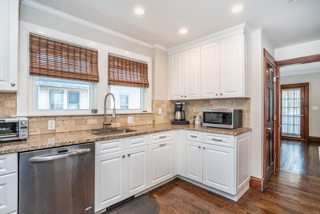 kitchen with dark wood-style floors, stainless steel appliances, crown molding, and a sink