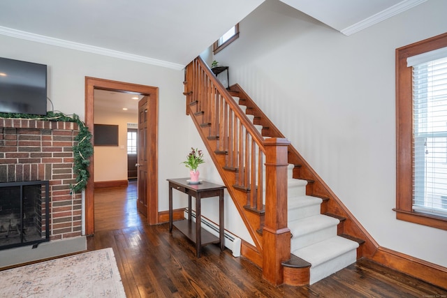 stairway with hardwood / wood-style floors, a fireplace, baseboards, and ornamental molding