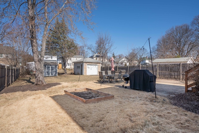 view of yard with an outdoor structure, a storage unit, a fenced backyard, and a patio area