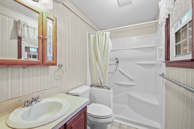 bathroom featuring visible vents, curtained shower, toilet, vanity, and a textured ceiling