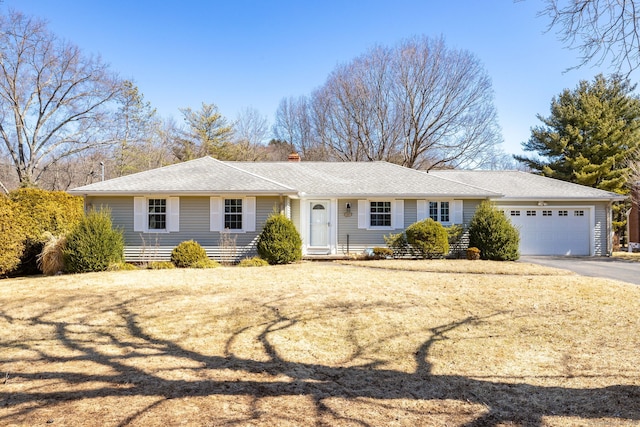 ranch-style home with aphalt driveway, a garage, and roof with shingles