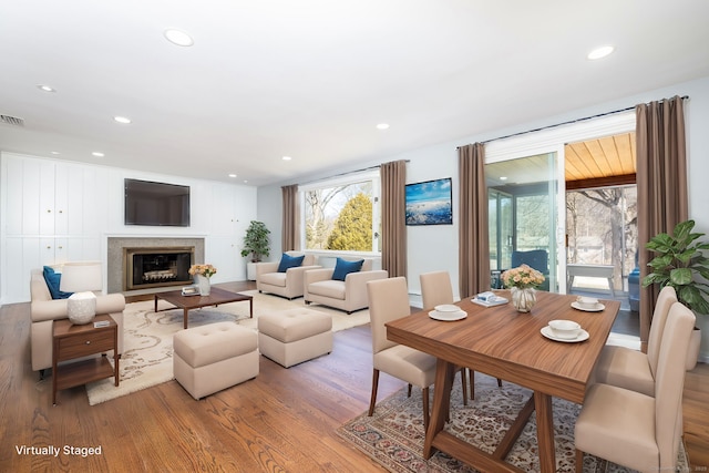 living area with recessed lighting, wood finished floors, visible vents, and a high end fireplace