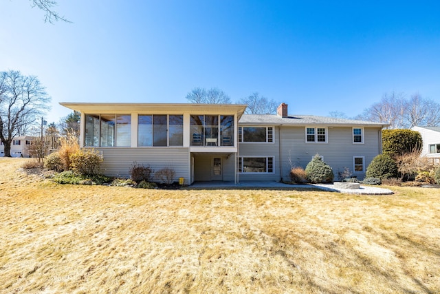 back of house featuring a patio area, a chimney, and a sunroom