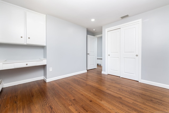 unfurnished bedroom with radiator, baseboards, visible vents, and built in study area