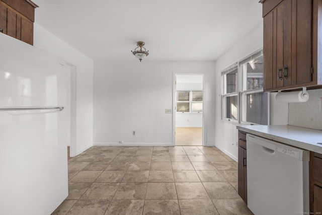 kitchen featuring white appliances, light tile patterned floors, light countertops, and baseboards