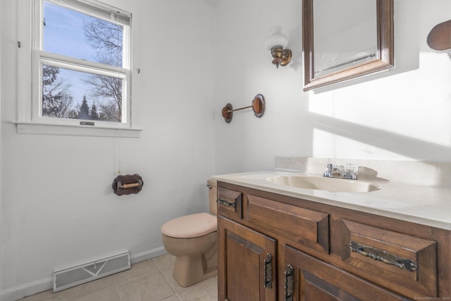 bathroom featuring vanity, visible vents, baseboards, tile patterned flooring, and toilet