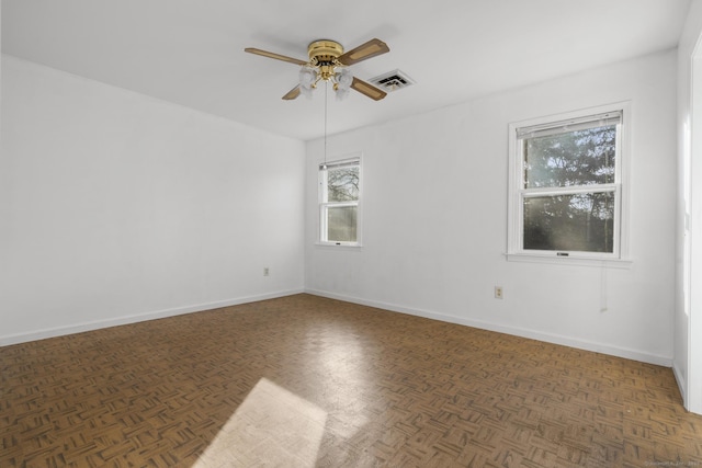 empty room with visible vents, baseboards, and a ceiling fan