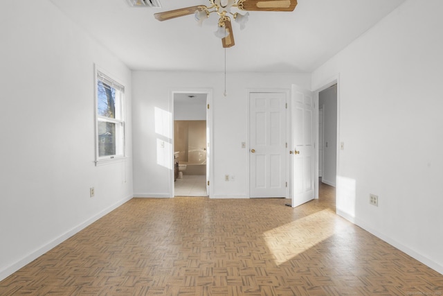 unfurnished bedroom with connected bathroom, baseboards, visible vents, and ceiling fan