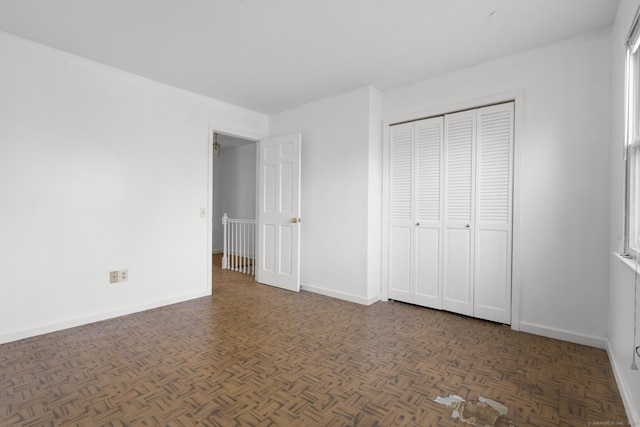 unfurnished bedroom featuring a closet and baseboards