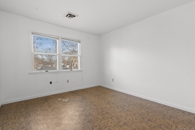 spare room featuring visible vents and baseboards