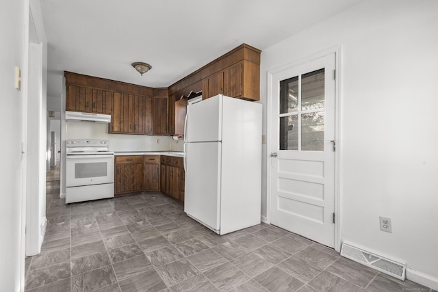 kitchen with white appliances, light countertops, visible vents, and under cabinet range hood