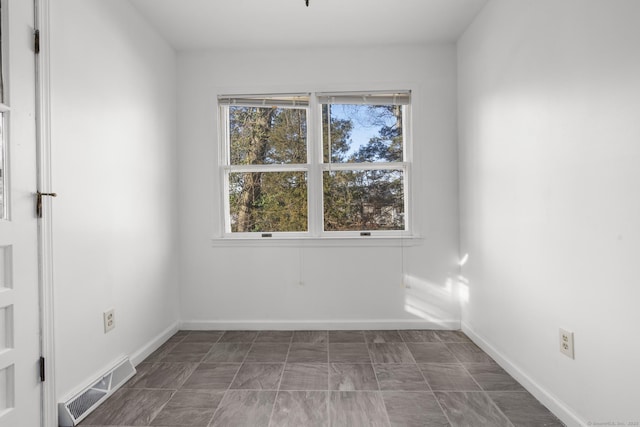 empty room with baseboards and visible vents